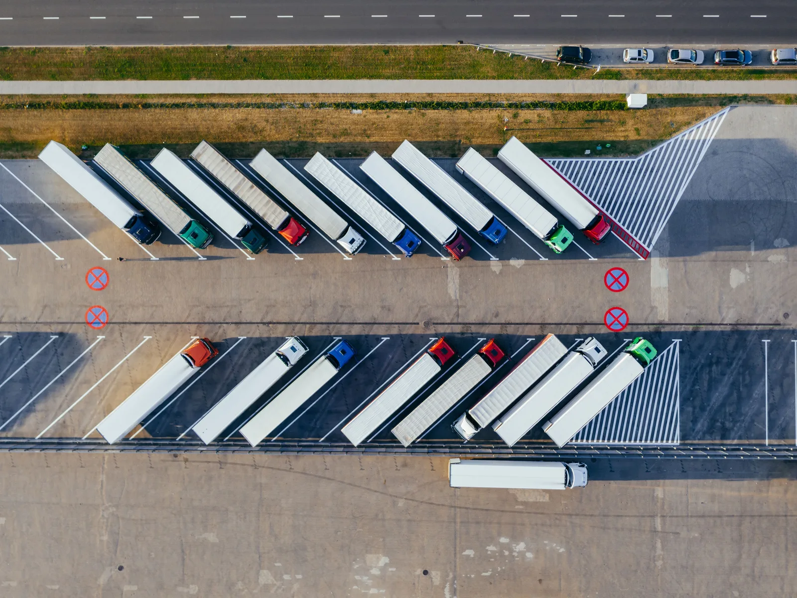 Aerial view of tractor-trailers parked in rows at a cross-border freight and logistics yard.
